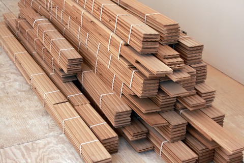 Pile of light hardwood flooring planks.