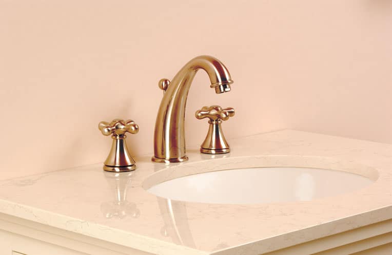 A split-set bathroom sink with a stone countertop on top of a bathroom cabinet.