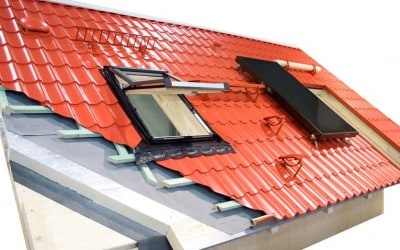 Cut-away diagram of a red metal roofing with insulation including internal and external parts, a skylight, and a solar panel.