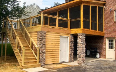 A dry storage room beneath an outdoor deck with screen porch and deck waterproofing system.