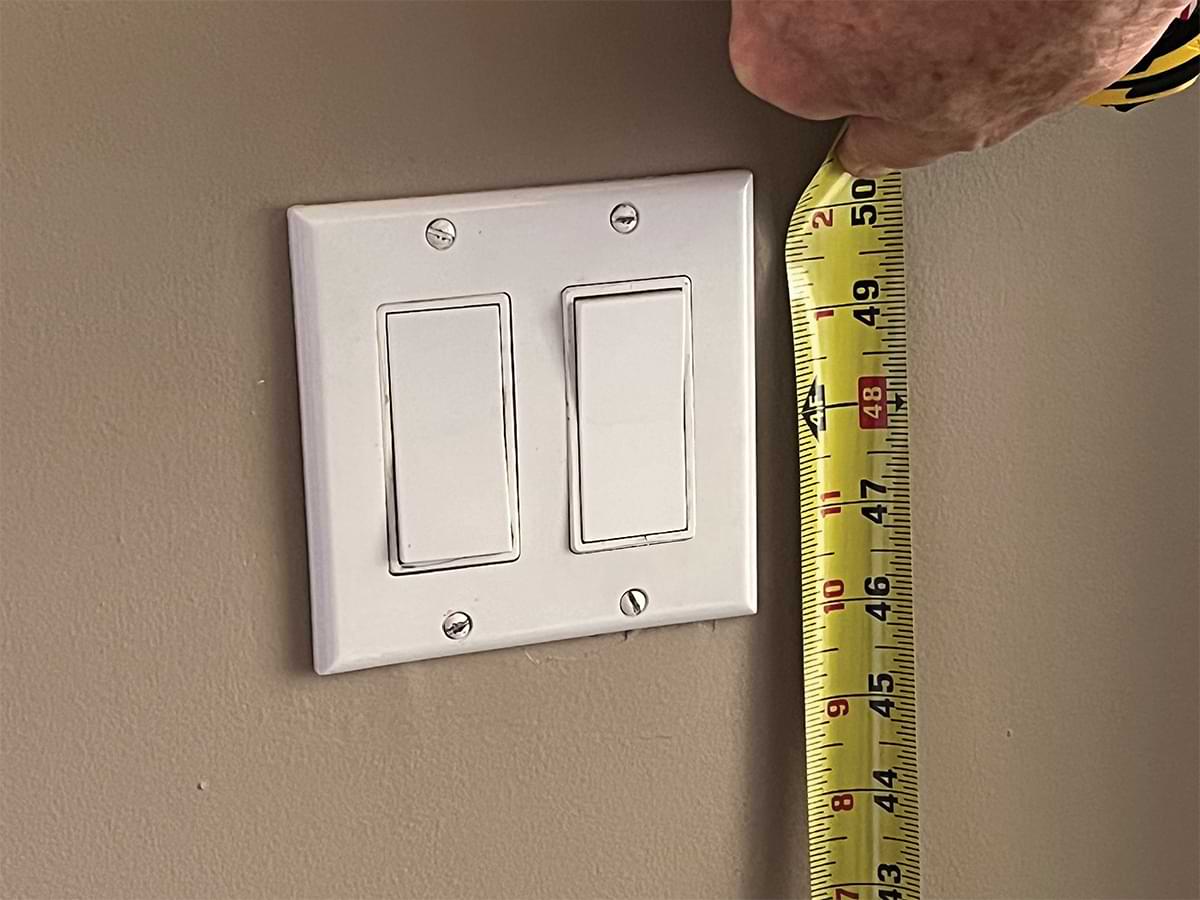 light switch and measuring tape with center of switch at 48-inch mark