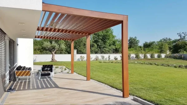 A wooden pergola with louvered slats takes center stage in this minimalist backyard, where clean lines and a neutral palette create a sense of calm.