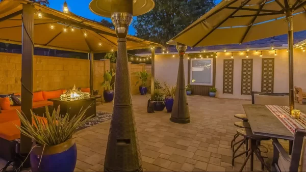 Two pergolas seamlessly connect two distinct seating areas in this backyard, creating a cohesive and functional outdoor living space.