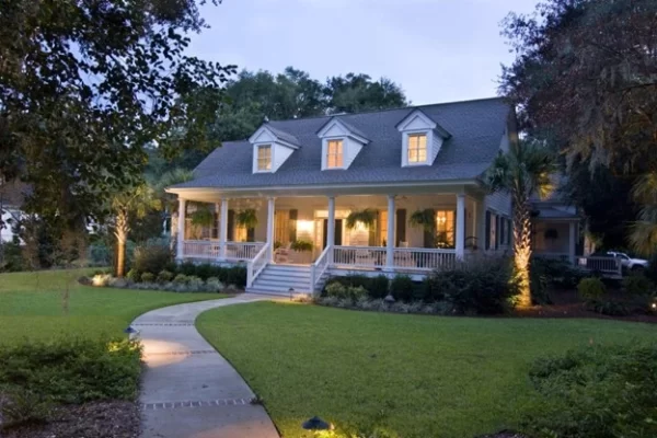 Curving lighted pathway guides guests to the welcoming porch of this classic home. 