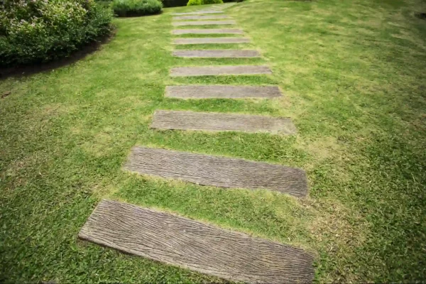 A serene and uncluttered pathway features evenly spaced wooden steps that blend seamlessly with the grassy surroundings.