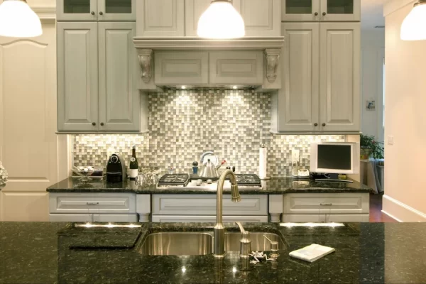 Cabinets in a neutral color palette, accented by a mosaic tile backsplash, give this kitchen a calm but visually interesting appeal.