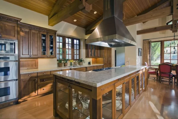 Glass door cabinets and countertop in light hues elevate the overall look of this kitchen island.