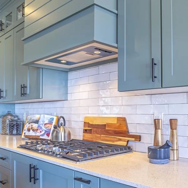 A backsplash of white subway tile combines with seafoam blue cabinets to create a friendly, coastal look in this kitchen.