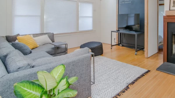 Caption: Gray and white pillows complement the neutral decor, while the yellow one adds a pop of color.