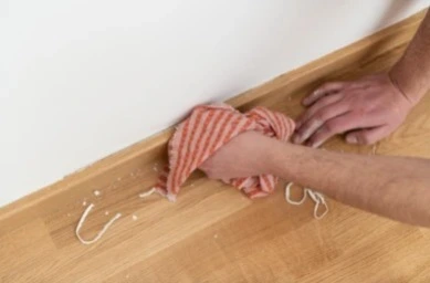 Person wiping the surface after removing silicone caulk