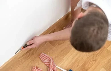 Someone slicing through the edge of silicone caulk