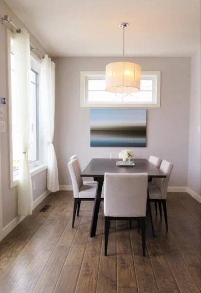 Keeping it simple, this minimalistic dining area has the bare essentials for dining: a table, chairs, and light—both natural and overhead.