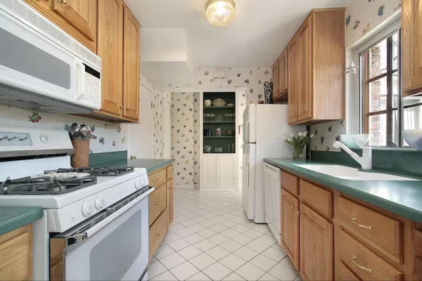 Lively floral wallpaper creates visual interest in this kitchen with a muted color palette.