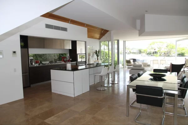 Open-plan home’s dining area is delineated by a sleek, modern table and chairs.