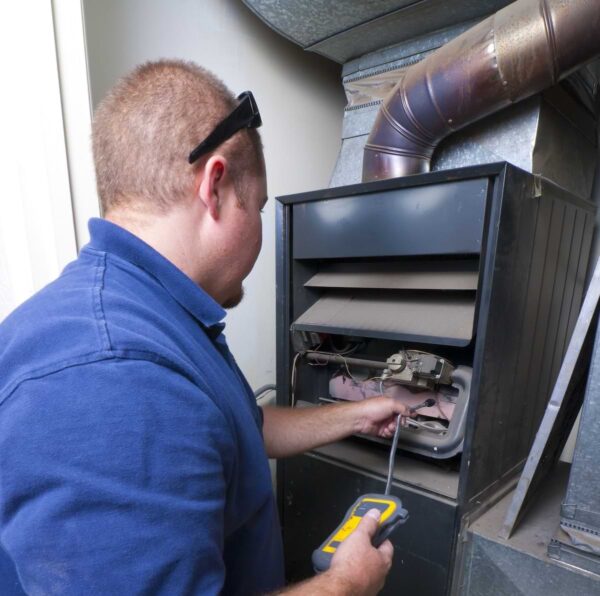 HVAC person repairing a furnace