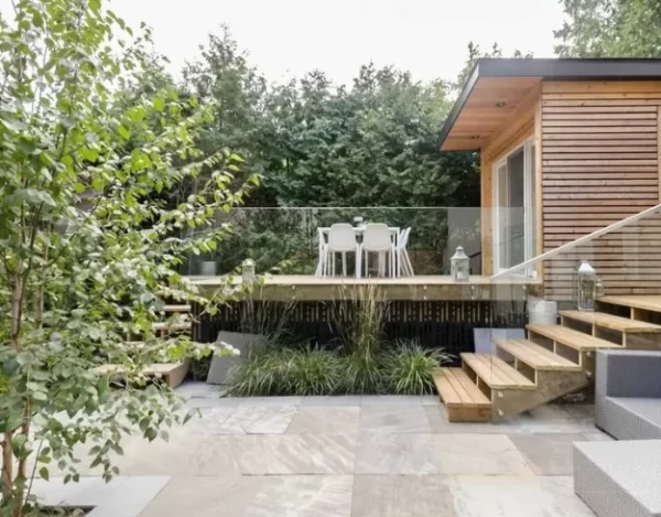 Glass panel railings give a clear, unhindered view of this lush, stylish backyard. 