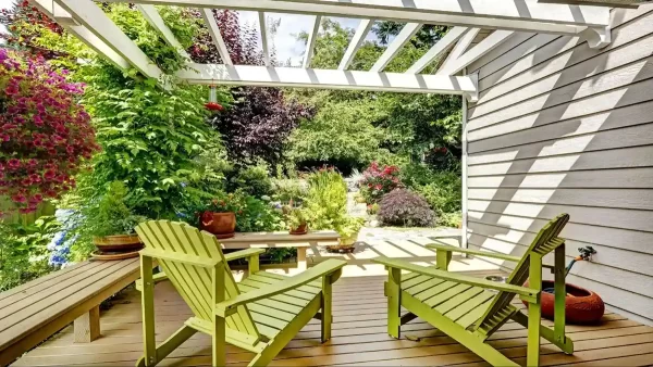 Lush greenery and a wood pergola create an intimate retreat on this private deck.