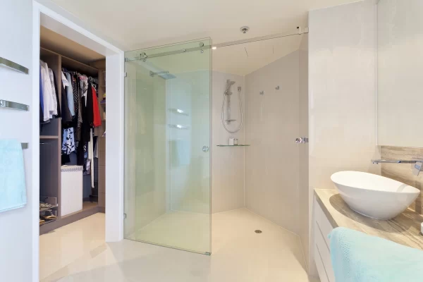 Light-toned tiles in the shower area create a cohesive and calm feel in this bathroom. 