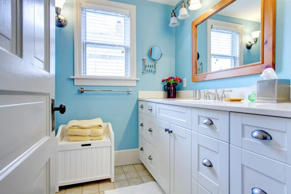 A big rectangular mirror reflects light and creates a sense of bigger space in this small bathroom.