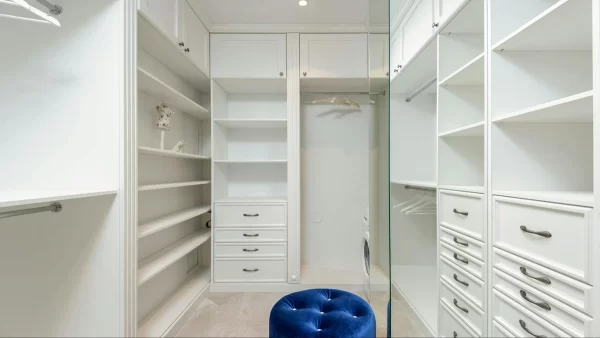 This walk-in closet has multiple drawers, open shelves and hanging spaces, which makes it ideal for those who need maximum storage space.