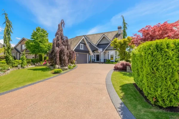 A wide driveaway looks like a visual retreat due to the surrounding greenery.