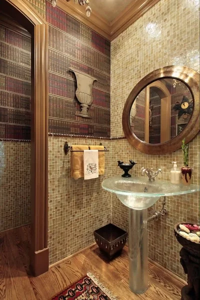 The round mirror with a heavy metallic frame enhances this bathroom design and is an excellent complement for the mosaic tiles.