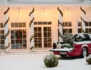 Simple wreaths garlands adorned with red bows and string lights emanate Christmas vibes.