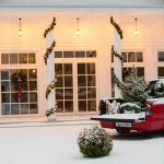 Simple wreaths garlands adorned with red bows and string lights emanate Christmas vibes.