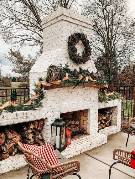 This fireplace is adorned with a wreath and large garland for a Christmas-like appeal.