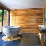 horizontal wood board paneling behind vessel bathtub and sinks