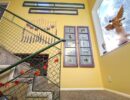 Stair landing decor that includes window frames with photos, mirrors, and more