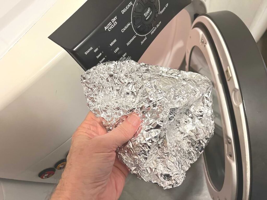 hand holding crumpled aluminum foil